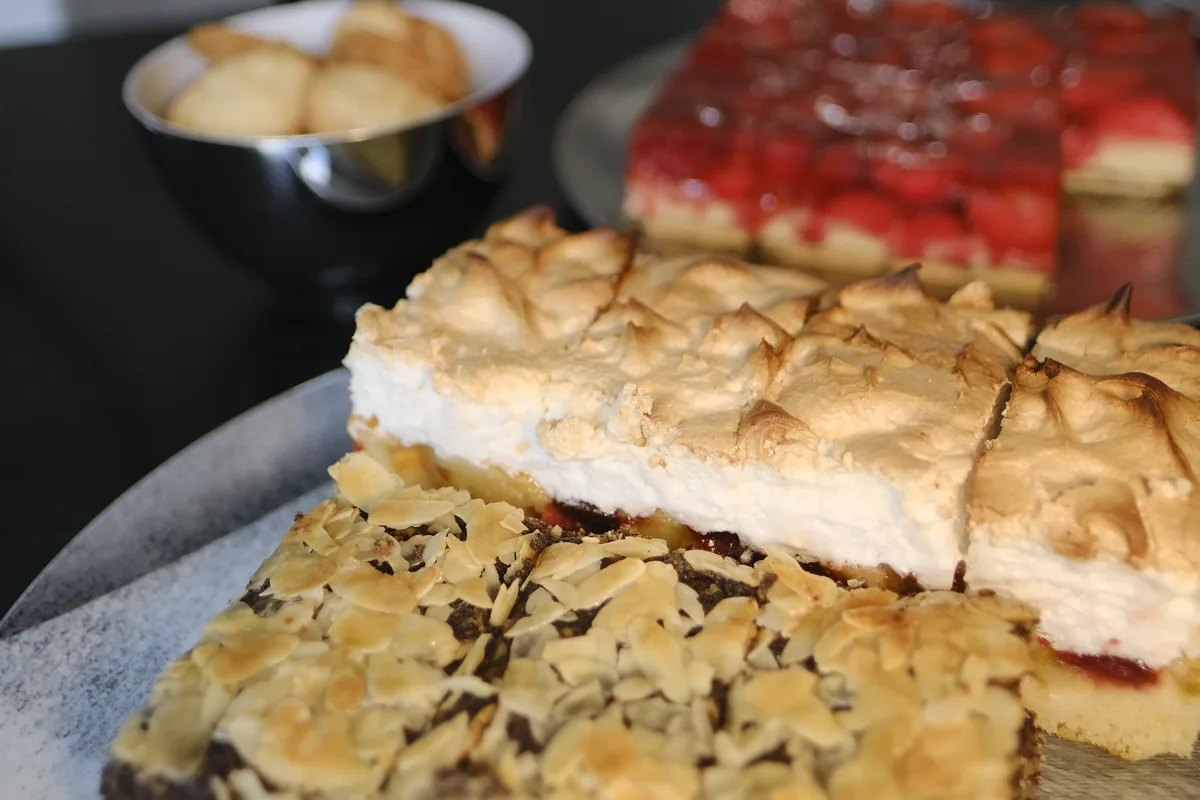 Drei Blechkuchen hintereinander: Mohn-Mandel, Kirsch mit Baiser und Erdbeer.