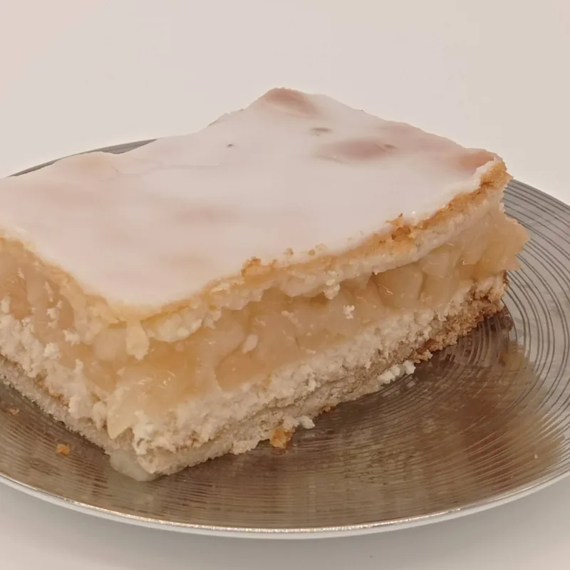 Ein Stück gedeckter Apfelkuchen mit Zuckerguss.