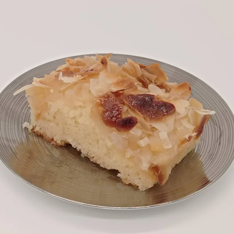 Ein Stück Butterkuchen mit Mandeln auf einem Teller.