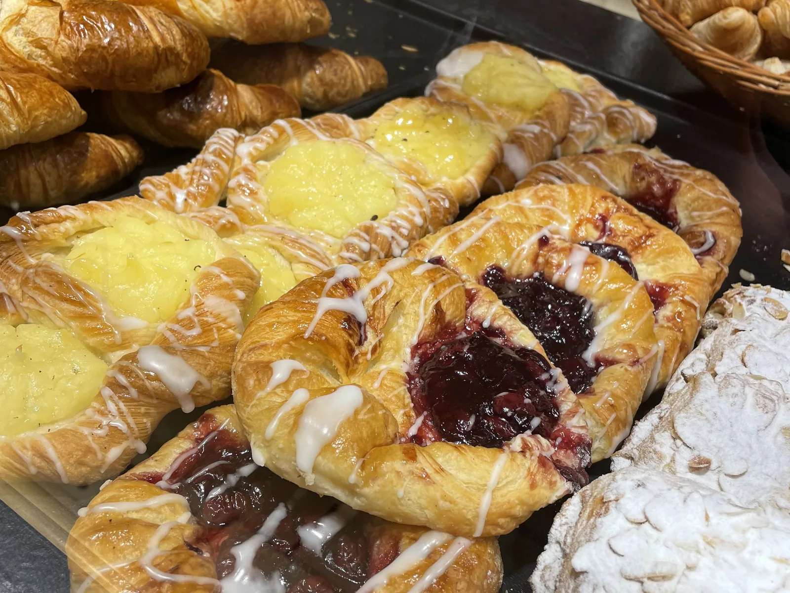 Plunderteilchen mit Puddingfüllung und Kirschen, frisch aus dem Ofen auf dem Blech.