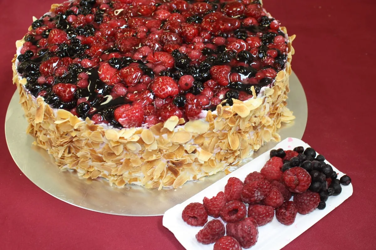 Eine Torte mit Himbeeren, Brombeeren und Mandelrand.